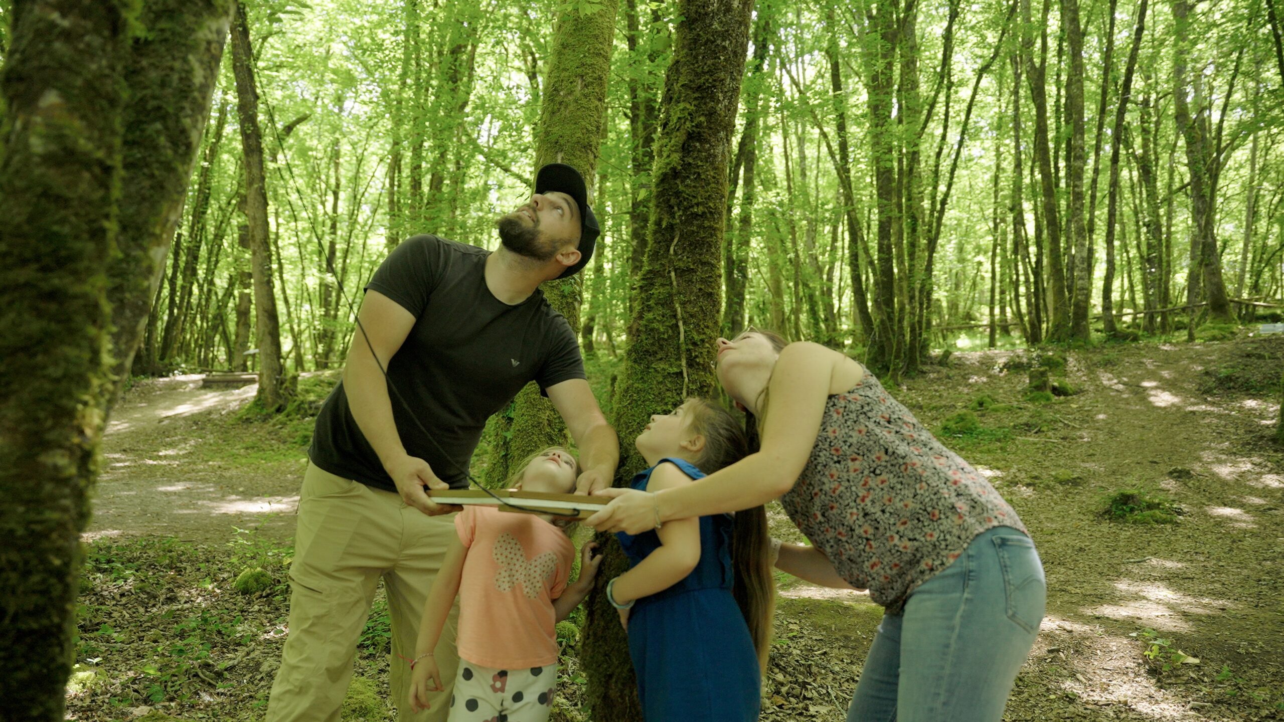 Famille résolvant une énigme avec le livret de jeu au Parc aux Dinosaures